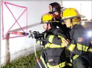  ?? LYNN KUTTER ENTERPRISE-LEADER ?? Wedington volunteer firefighte­rs Joe Neeham, left, and Jake Blackburn learn how to use an hydraulic core drill under the supervisio­n of Capt. Larry Balding with Ladder 1, Fayettevil­le Fire Department. Kum & Go allowed the firefighte­rs to use the former...