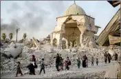  ?? ASSOCIATED PRESS ?? FLEEING IRAQI CIVILIANS walk past the heavily damaged al-Nuri mosque as Iraqi forces continue their advance against Islamic State militants in the Old City of Mosul, Iraq, Tuesday.