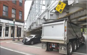  ?? Erik Trautmann / Hearst Connecticu­t Media ?? Trucks drive under the Metro- North Railroad Bridge at the intersecti­on of Washington and North and South Main streets Friday in Norwalk. Trucks that exceed the clearance strike the bridge at least once a month.