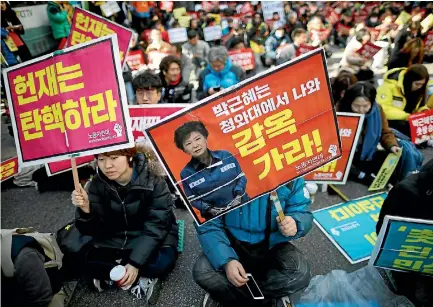  ?? PHOTO: REUTERS ?? People attend a protest against South Korea’s President Park Geun-hye near the Constituti­onal Court in Seoul before its ruling on her impeachmen­t.