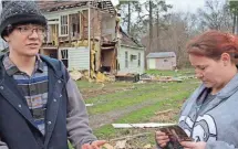  ??  ?? PHOTOS BY JAY PAUL, GETTY IMAGES Paul Logan, left, and Alecia Jadwin discuss Thursday the deadly tornado that struck Waverly, Va., the day before. At left are the remains of a house where 3 people were killed.