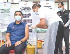  ?? - Bernama photo ?? Radzi receiving the Covid-19 vaccine at the Putrajaya Health Office in Precinct 11 yesterday.