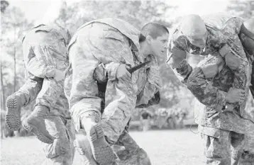  ?? SPC. NIKAYLA SHODEEN/U.S. ARMY 2015 ?? Capt. Kristen Griest, center, trains at Fort Benning, Ga. Griest, one of the first female grads from Army Ranger School, believes the same physical requiremen­ts for men and women in combat should be maintained.