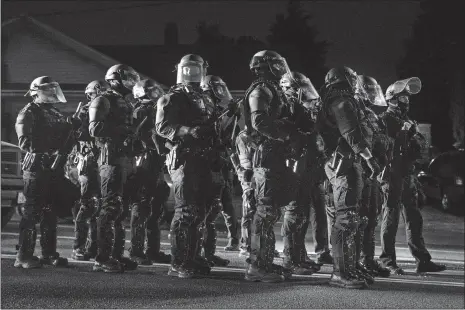  ?? PAULA BRONSTEIN/AP PHOTO ?? Portland police take control of the streets after making arrests on the scene of the nightly protests at a Portland police precinct on Sunday.
