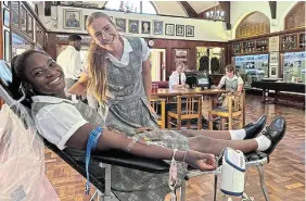  ?? Picture: JACKIE CLAUSEN ?? LEADING BY EXAMPLE: Kingswood College head girl and waterpolo captain Matipa Karimazond­o, reclining, donated a unit of blood when the mobile unit of the SA National Blood Service (SANBS) from Gqeberha set up their blood collection clinic in the school museum last Thursday. Supporting her was friend Amy Wilson. The SANBS was well-pleased with the 42 units of the life-saving fluid donated on the day.
