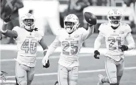  ?? ELSA Getty Images ?? Xavien Howard, center, celebrates with teammates after making an intercepti­on against Jets quarterbac­k Sam Darnold. It was his league-leading seventh intercepti­on of the season.