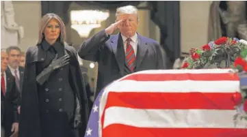  ?? PATRICK SEMANSKY/AP ?? President Donald Trump salutes alongside first lady Melania Trump in front of the flag-draped casket of former President George H.W. Bush in the Capitol Rotunda on Monday.