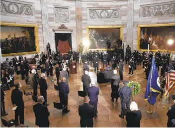  ?? BRENDAN SMIALOWSKI AP ?? People attend a ceremony memorializ­ing U.S. Capitol Police Officer Brian Sicknick as an urn with his cremated remains lies in honor in the Capitol Rotunda on Feb. 3. He died after the attack on the U.S. Capitol.