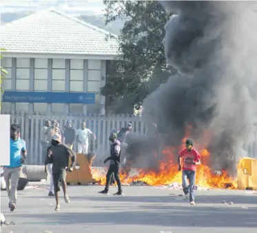  ??  ?? Protesters flee the entrance to the Mbombela Taxi Rank in Henshall Street.