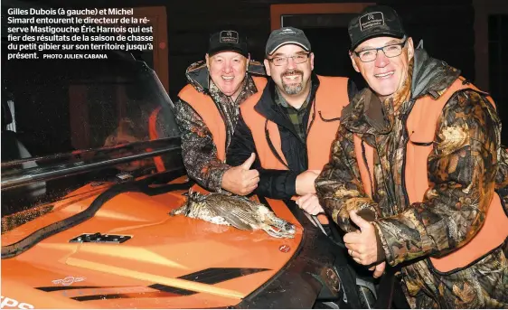  ?? PHOTO JULIEN CABANA ?? Gilles Dubois (à gauche) et Michel Simard entourent le directeur de la réserve Mastigouch­e Éric Harnois qui est fier des résultats de la saison de chasse du petit gibier sur son territoire jusqu’à présent.