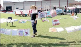  ??  ?? Sally Zelenka, a member of the city’s Economic Developmen­t Committee, was in charge of a children’s art show at the Farmington Fall Festival on Saturday. She kept busy making sure the wind did not blow any of the children’s artwork from the clotheslin­e.