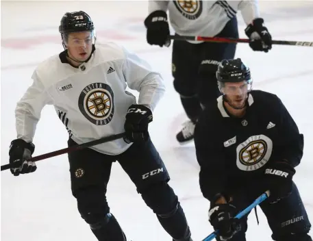  ?? NAncy lAnE pHOTOS / BOSTOn HErAld filE ?? ON THE BRINK: Bruins defenseman Charlie McAvoy, right, skates with center David Krejci on Thursday at Warrior Ice Arena, Top left, Jeremy Lauzon talks with coach Bruce Cassidy.