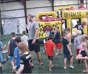  ??  ?? Coach Cody Alexander instructed the young Blackhawks who were eager to enter the bounce house and practice climbing and other physical skills.
