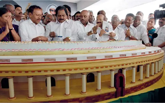  ??  ?? AIADMK MEMBERS CUTA 66-KG CAKE DEPICTING PARLIAMENT ON JAYALALITH­AA’S BIRTHDAY