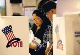  ?? Allen J. Schaben ?? ADRIANA AND JESUS MATA cast ballots in the California primary in June. Big turnout among Latinos could influence down-ballot races and propositio­ns.