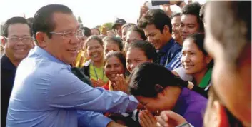  ?? — Reuters ?? Garment workers welcome Prime Minister Hun Sen during a rally in Kandal province on May 30.