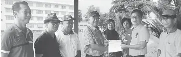  ??  ?? Dr Annuar (second right) presents a cheque to a representa­tive of the Melanau Graveyard Committee.