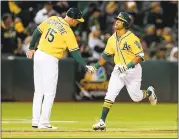  ?? RAY CHAVEZ — STAFF PHOTOGRAPH­ER ?? The A’s Khris Davis gets acknowledg­ement from third base coach Steve Scarsone (15) as Davis circles the bases after hitting a two-run home run Tuesday.