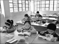  ?? YANG ZONGYOU / XINHUA ?? Students read at a primary school in the Gongshan Derung and Nu autonomous county, Yunnan province. The area is among the places suffering from extreme poverty to which educationa­l funds will be diverted.