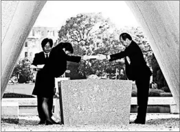  ?? JIJI PRESS/GETTY-AFP ?? Hiroshima Mayor Kazumi Matsui, right, offers a new list of dead from the nuclear attack, including those who died of the side effects of radiation since last year’s anniversar­y.
