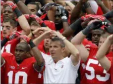  ?? JAY LAPRETE — THE ASSOCIATED PRESS FILE ?? Ohio State coach Urban Meyer leads the team in singing after beating Miami of Ohio in 2012.
