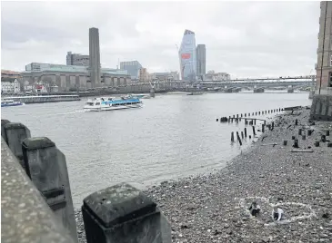  ??  ?? Volunteers make a heart from bottles that were washed up along the Thames River in England.