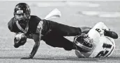  ?? Tom Reel / Staff photograph­er ?? Harlan receiver Shomari Anderson stretches for more yards after a catch against Winn High School.