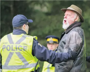  ??  ?? Retired opera performer Gary Reylea begins to sing as he is arrested last Wednesday at the gates of Kinder Morgan Canada’s Burnaby Mountain work site for the Trans Mountain pipeline expansion.