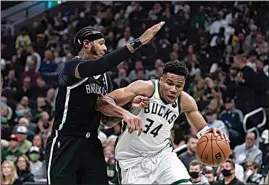  ?? MORRY GASH / AP ?? The Milwaukee Bucks’ Giannis Antetokoun­mpo (34) is defended by the Brooklyn Nets’ James Johnson during the first half Tuesday in Milwaukee. The Bucks won 127-104.