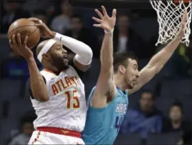  ?? CHUCK BURTON — THE ASSOCIATED PRESS ?? The Hawks’ Vince Carter (15) grabs a pass as Charlotte Hornets’ Frank Kaminsky defends Nov. 28 in Charlotte, N.C.