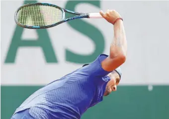  ?? THE ASSOCIATED PRESS ?? Nick Kyrgios breaks his racket Thursday in his second-round match against Kevin Anderson at the French Open. Anderson won 5-7, 6-4, 6-1, 6-2.