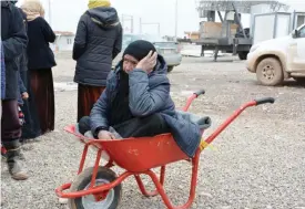  ??  ?? KHAZIR: A displaced Iraqi woman, who fled the violence around the northern Iraqi city of Mosul, sits inside a trolley as she waits to receive food aid at the Al-Khazer refugee camp some 40 kilometers east of Arbil. — AFP