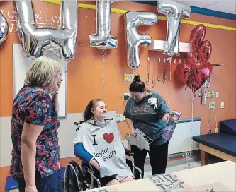  ?? COURTESY CHILDREN’S HOSPITAL OF MICHIGAN
THE CANADIAN PRESS ?? Tiffany Kleinschmi­dtof Waterford, Mich. is shown with Taylor Swift merchandis­e. Tiffany, a 15-year-old fan who’s attending Taylor Swift’s Tuesday night show with the help of a nurse from Quebec, would have found it impossible to sing along with her favourite artist just a few months ago.