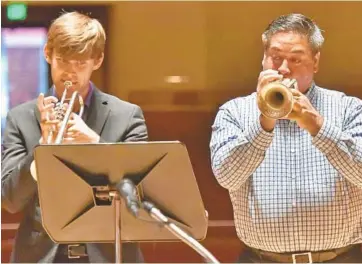  ?? AMY DAVIS/BALTIMORE SUN PHOTOS ?? BSO musicians Matt Barker and Rene Shapiro play at a news conference to announce the end of the labor dispute.