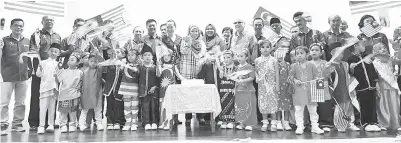  ??  ?? JAINAB bersama kanak-kanak Tadika Perpaduan semasa pelancaran Program Kibar Jalur Gemilang.