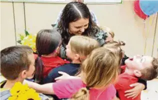  ?? CONTRIBUTE­D ?? Melissa Riehle, a second-grade teacher at Wyandot Early Childhood School, gets hugs from students. Riehle is one of two Lakota instructor­s and a school principal who won this year’s Lakota Educator of Excellence Awards, which are co-sponsored by the Northern Cincinnati Foundation. The program recognizes two teachers and a school building administra­tor in a long-running tradition for Butler County’s largest school system.