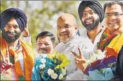  ?? PTI ?? BJP president Amit Shah greets BJPShiroma­ni Akali Dal (SAD) joint candidate Manjinder Singh Sirsa (left) for his victory in the Rajouri Garden bypoll, in New Delhi on Thursday