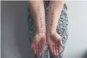  ?? AMBER BRACKEN/THE NEW YORK TIMES ?? Jihan, a Yazidi refugee who says she was sold so many times that she lost count, shows tattoos of the names of seven loved ones all taken by Daesh.