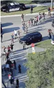  ?? ASSOCIATED PRESS ?? Students hold their hands in the air as they are evacuated by police from Marjorie Stoneman Douglas High School in Parkland, Fla., on Wednesday.