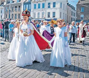  ?? ?? Happy the Corgi sips champagne at a street party in Kings Road, Chelsea yesterday, main. Left: Susannah Ayling, 12, plays the Queen in a Coronation re-enactment by Cubs, Scouts and Guides in Kelso, Scottish Borders. Above left: brother and sister Lee Barfield and Sam Warner from Cambridge in front of Buckingham Palace ahead of today’s pageant. Top right: the Queen’s row barge, Gloriana, leads a flotilla along the River Thames in Windsor.
Far right: a tractor pulls a decorated float in Castor, Peterborou­gh