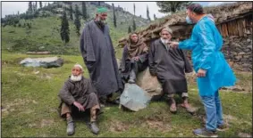  ??  ?? Kashmiri nomads listen to Dr. Sayeed Idrees on June 21 during a covid-19 vaccinatio­n drive in Tosamaidan.