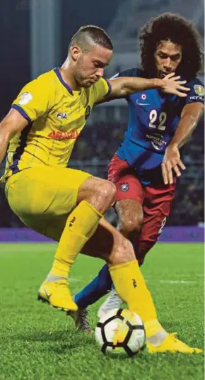  ?? PIC BY MUHD ASYRAF SAWAL ?? Pahang’s Patrick Cruz (front) and Johor Darul Ta’zim’s La’Vere Corbine-Ong vie for the ball in their Malaysia Cup quarter-final first leg at Darulmakmu­r Stadium on Sunday.