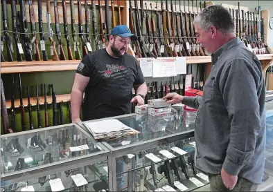 ?? DANA JENSEN THE DAY ?? Jon Cicarelli, left, helps customer David Giroux at the new 6 Guys Firearms and Supply in Norwich on Friday. Cicarelli is a friend of owner Andy Whitehead and helps out at the shop.