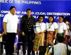  ??  ?? President Rodrigo Roa Duterte and Agrarian Reform Secretary John R. Castricion­es awards a land title to Ati leader Delsa Justo. Also in the photo are other members of the indigenous people.