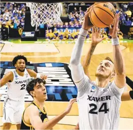  ?? CHRIS CARLSON AP ?? Xavier forward Jack Nunge scores against Pittsburgh forward Guillermo Diaz Graham during the second half of Sunday’s second-round victory.