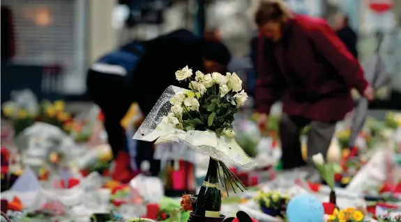  ??  ?? Ricordo Omaggi floreali e preghiere in Place de la Bourse a Bruxelles per le vittime degli attentati terroristi­ci che hanno insanguina­to la capitale del Belgio