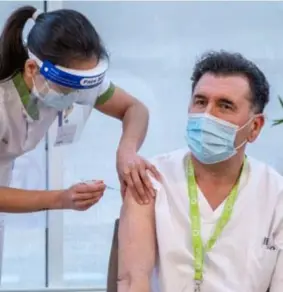  ?? FOTO'S JORIS HERREGODS ?? 13u: Hoofdverpl­eegkundige Luc Clement krijgt van Sissy Liu het eerste Modernavac­cin.