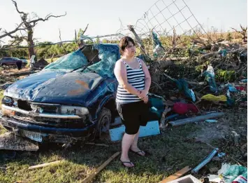  ?? Foto: Sarah A. Miller/Tyler Morning Telegraph, dpa ?? Diese Frau steht vor den Trümmern ihres Hauses in Canton. Auch ihr Auto hat der Sturm zerstört. Trotzdem hatte sie Glück. Eine 72 Jährige starb, nachdem die Fluten ihr Fahrzeug erfasst hatten.