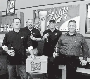  ??  ?? Oblio’s co-owners Mark Schultz, left, and Todd Cummings, second from right, welcome the return of Schlitz Beer in 2009. Schultz is now in an intensive care unit with COVID-19. OSHKOSH NORTHWESTE­RN MEDIA