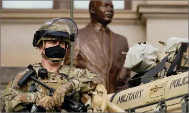  ?? (AP/John Bazemore) ?? A Georgia National guard member stands watch Sunday in front of a statue of Martin Luther King Jr. outside the Georgia Capitol in Atlanta.